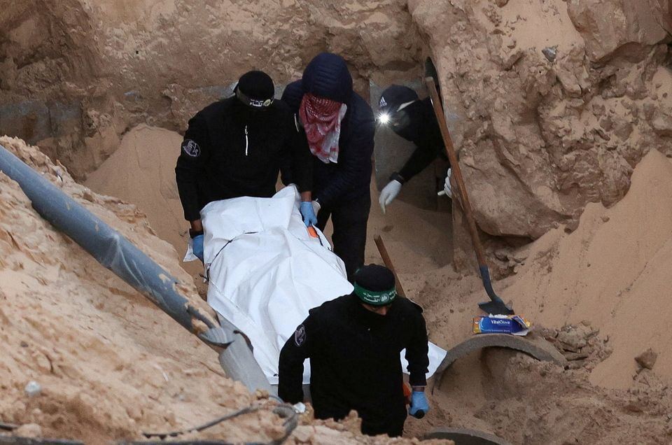 Hamas militants carry a dead body during a search for deceased hostages seized by Hamas, in Khan Younis. Photo: Reuters